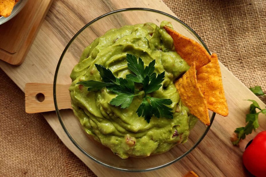 Guacamole in a bowl with tortilla chips on the side